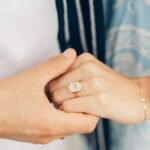 two hands holding each other with an engagement ring